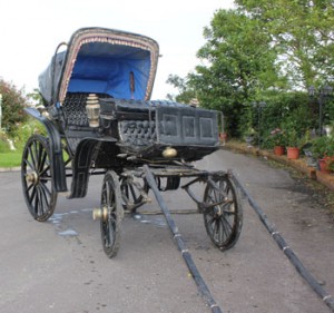 A black carriage, upholstered in leather, with original fittings