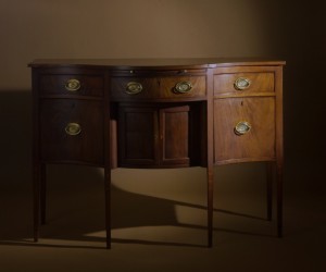 Nathan Liverant and Son LLC. A diminutive Federal Mahogany Sideboard, featuring a serpentine front, straight tapered legs and unusual floral and stringing inlay decoration. Portsmouth, New Hampshire or possibly Rhode Island, 1785 - 1810. Mahogany with Eastern White Pine secondary wood.