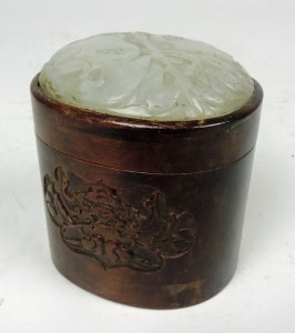 A 19th century carved oval hardwood box with jade lid.