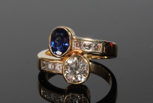 A diamond and sapphire cross over ring (6,000-7,000)